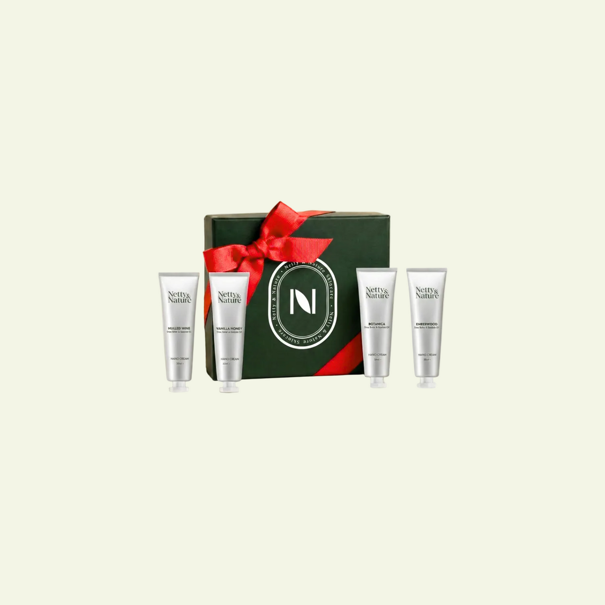 Netty & Nature Mini Giftset — deep-green gift box with a red ribbon and four travel-size hand cream tubes